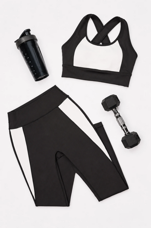 Black and white color block style sports bra, leggings, shaker bottle, and dumbbell on a white background