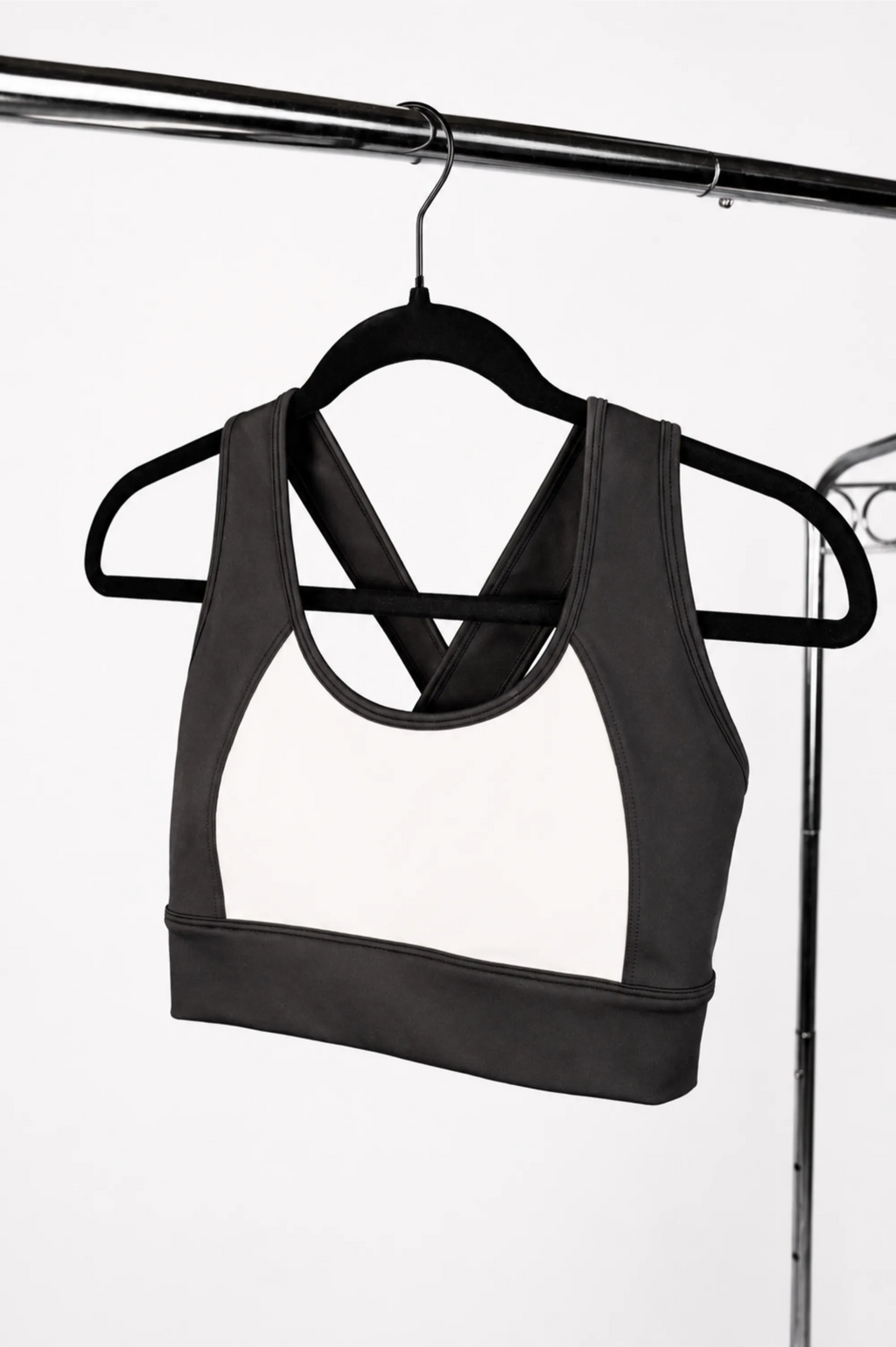 Black and white sports bra on a hanger against a white background