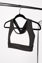Black and white sports bra on a hanger against a white background
