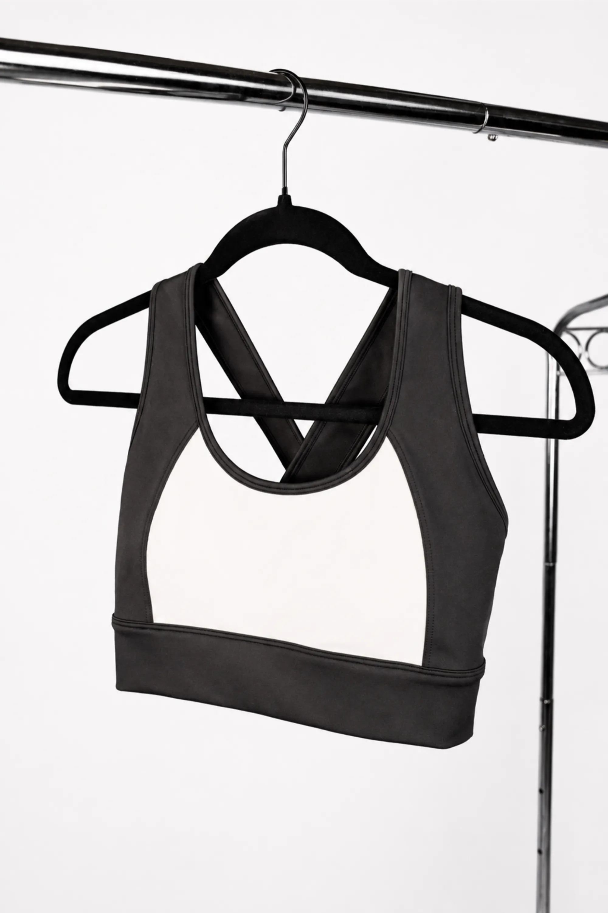 Black and white sports bra on a hanger against a white background